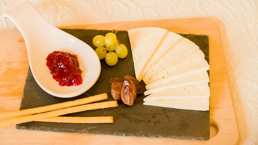 Tabla de queso con mermelada, dátiles y uvas. De artesanos Lácteos